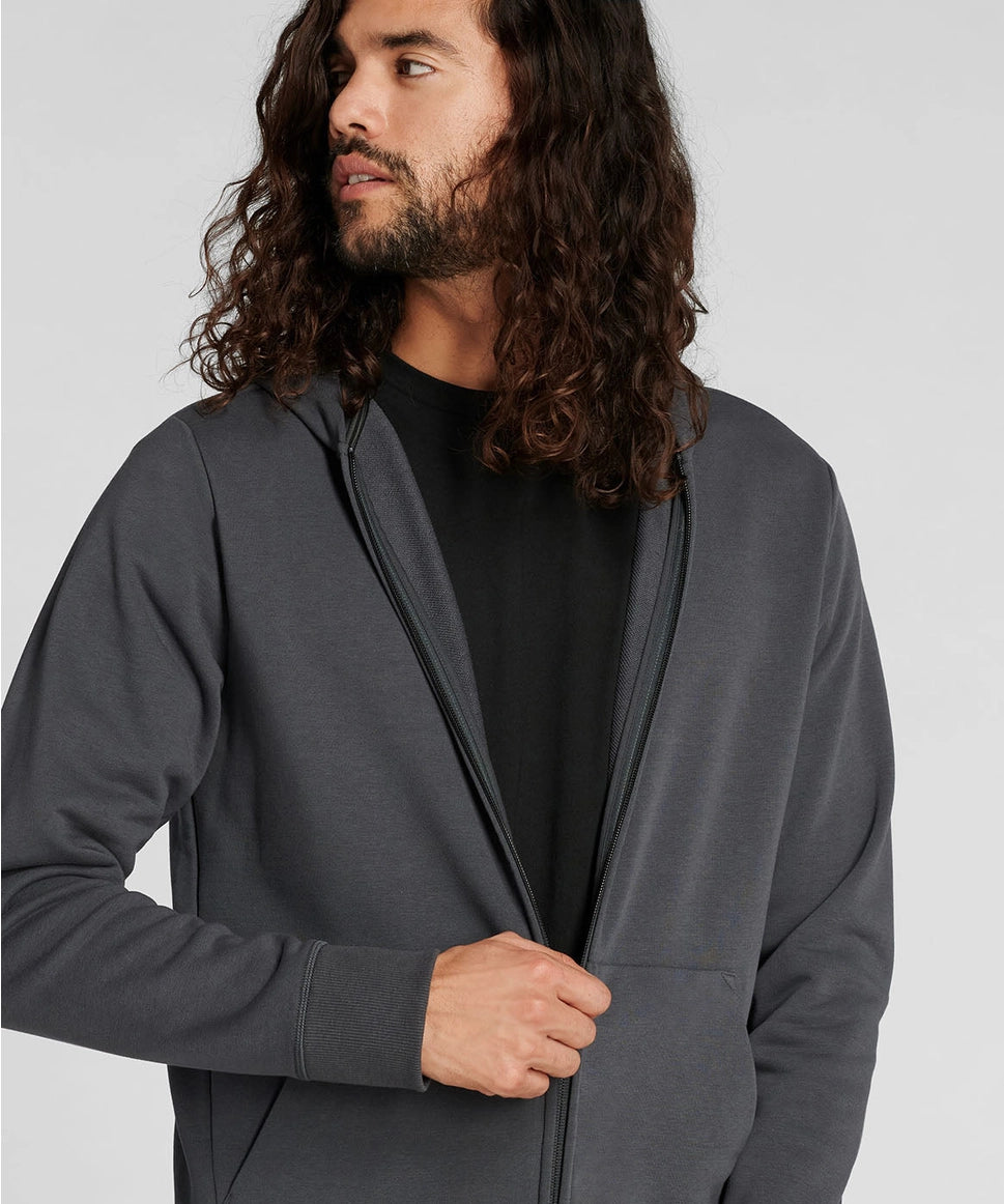 Man wearing a gray hoodie against a plain background RYU