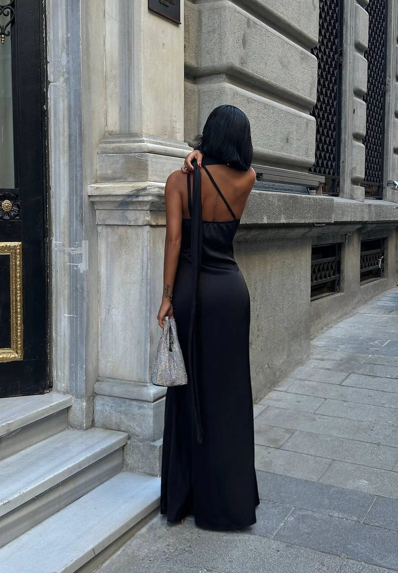 Woman in a black dress standing on a city street. Standpoint Top