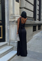 Woman in a black dress standing on a city street. Standpoint Top