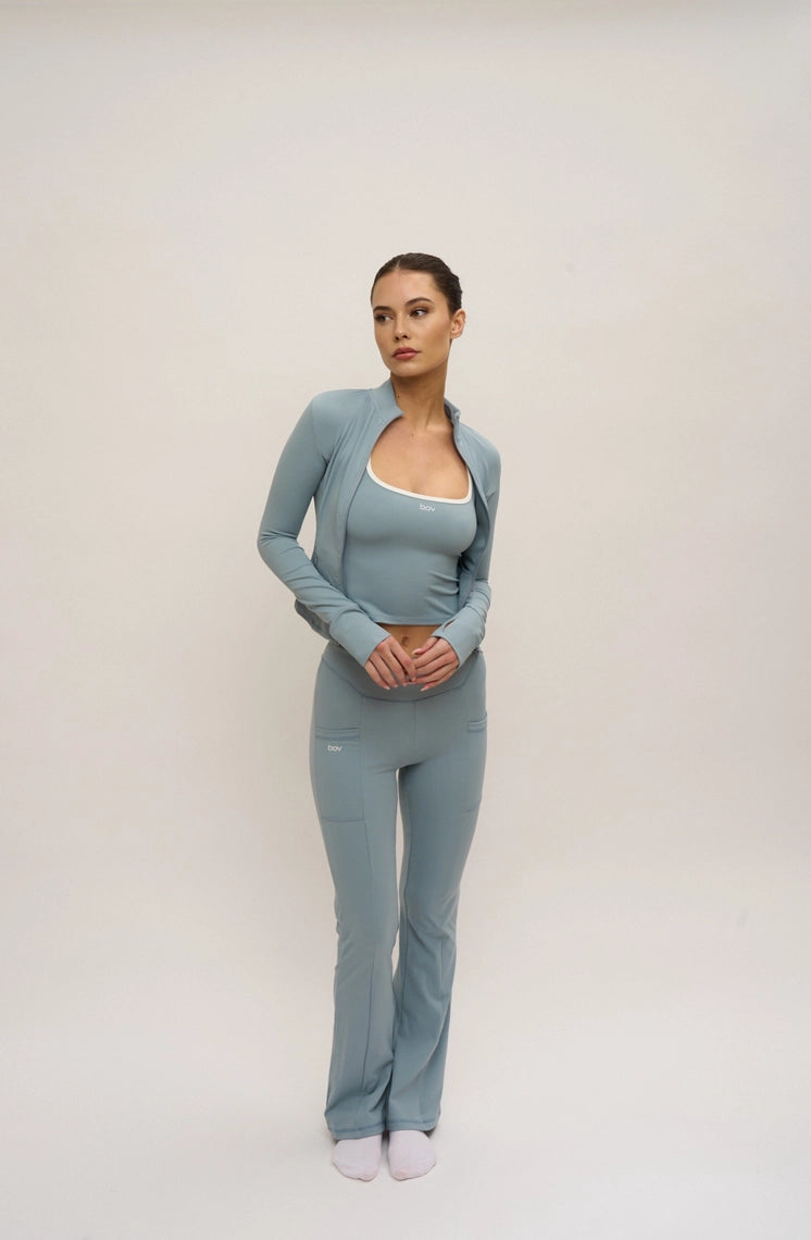 Woman wearing a light blue outfit on a plain background