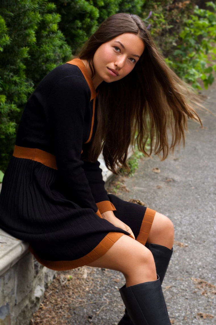 Woman wearing Clarissa knit dress in navy with white contrast trim, full length view
