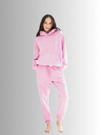 Woman wearing a pink hoodie and pants set on a gray background PRIV