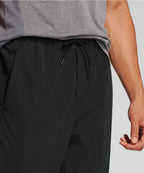 Man wearing black pants and a gray top on a light gray background RYU