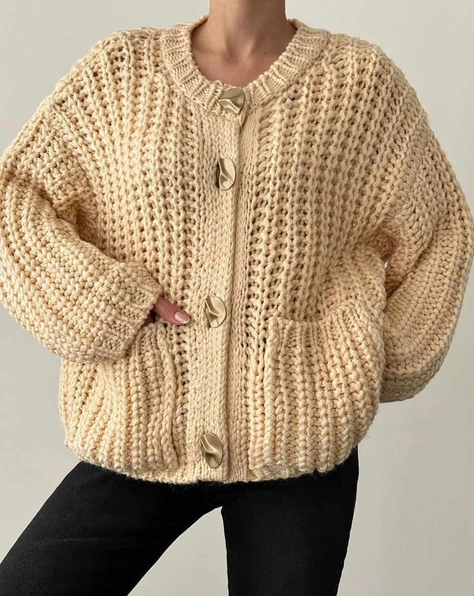 Beige knitted cardigan worn by a person on a plain background ANAZ