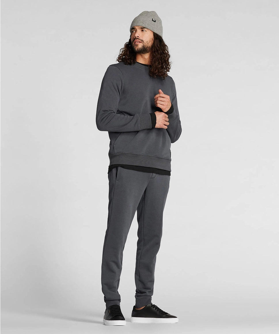 Man wearing a gray sweatshirt and pants with a beanie on a white background RYU