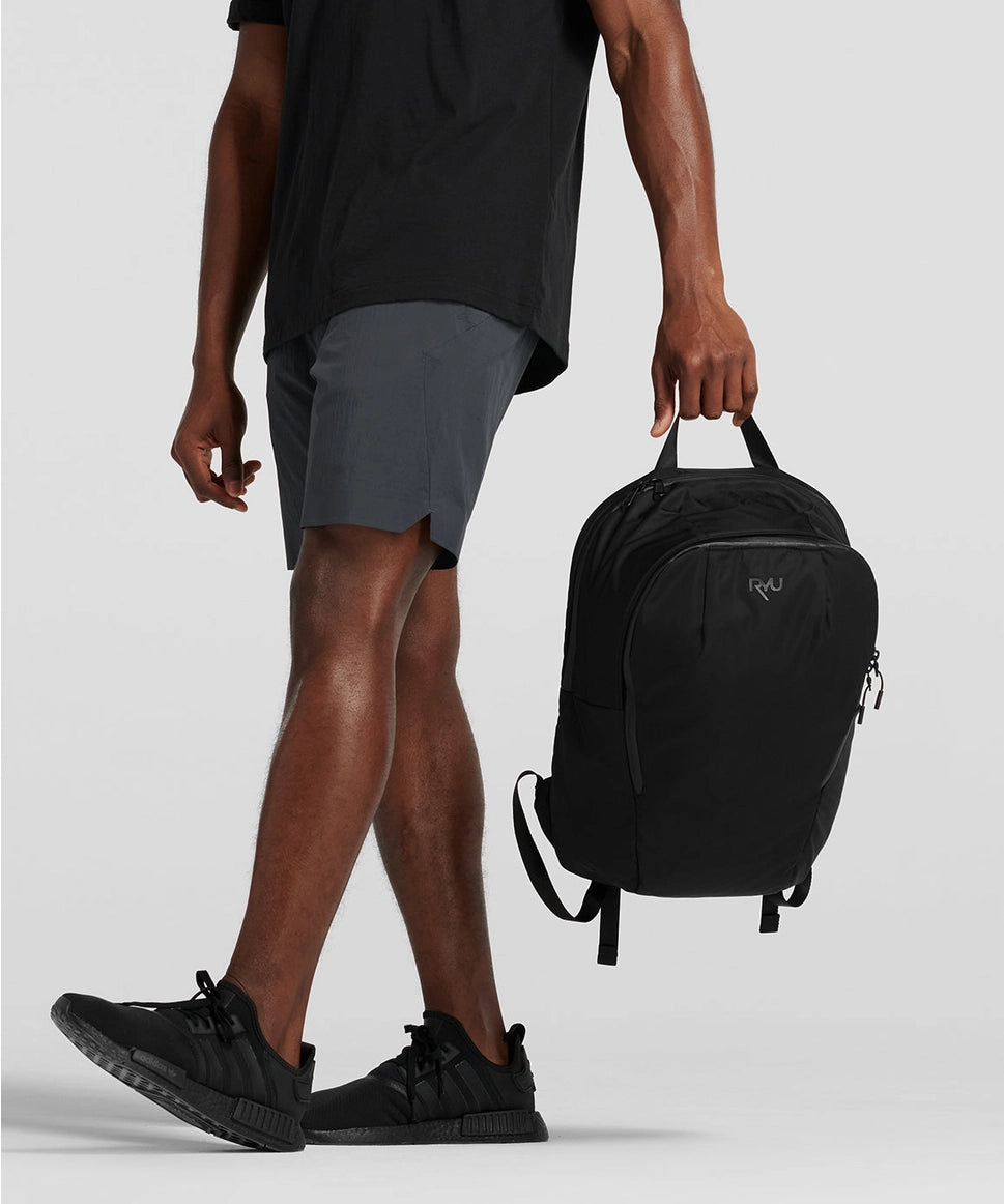 Person holding a black backpack with a plain background RYU