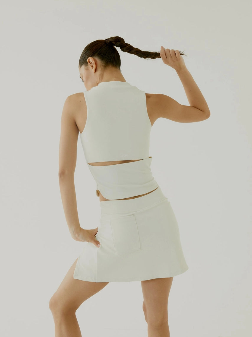 Woman wearing a cream skirt BOV with cut-out design on a plain background