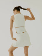 Woman wearing a cream skirt BOV with cut-out design on a plain background