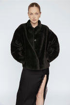 Woman wearing a black fur coat against a white background Amanda Maria