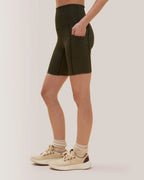 Women wearing olive green shorts and beige sneakers on a plain background Rose Boreal