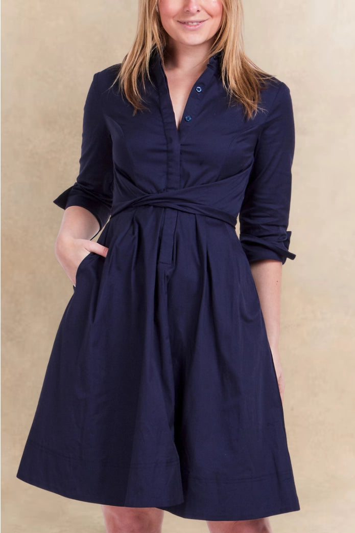 Woman wearing a navy blue dress with a beige background ANNICK