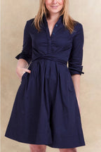 Woman wearing a navy blue dress with a beige background ANNICK