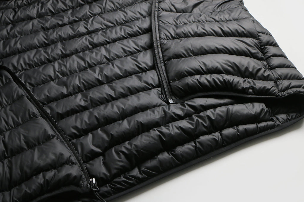 Close-up of a black puffer jacket on a light gray background Aparso
