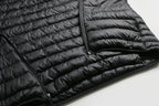 Close-up of a black puffer jacket on a light gray background Aparso