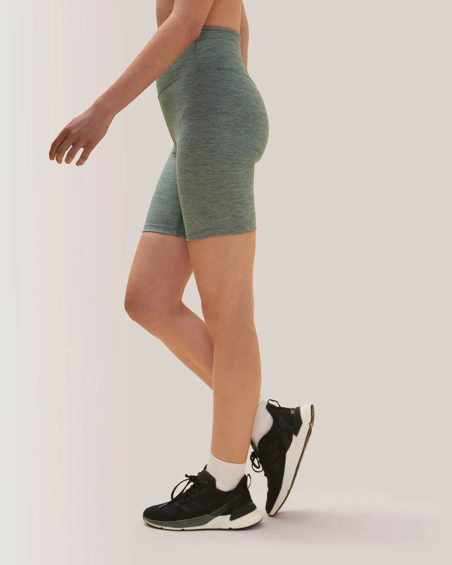 Women wearing green athletic shorts and black sneakers on a white background Rose Boreal