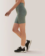 Women wearing green athletic shorts and black sneakers on a white background Rose Boreal