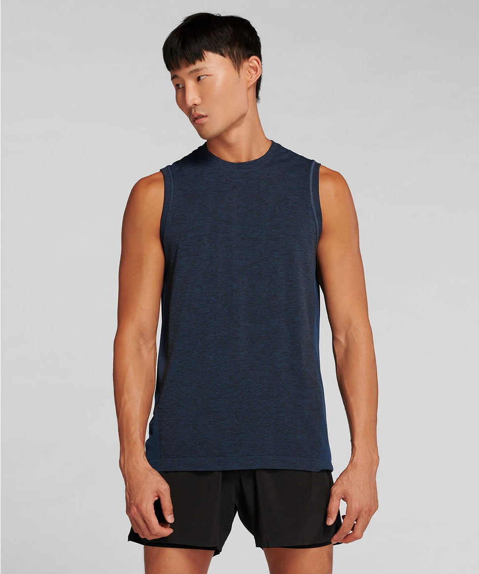 Man wearing a navy sleeveless shirt and black shorts on a gray background RYU