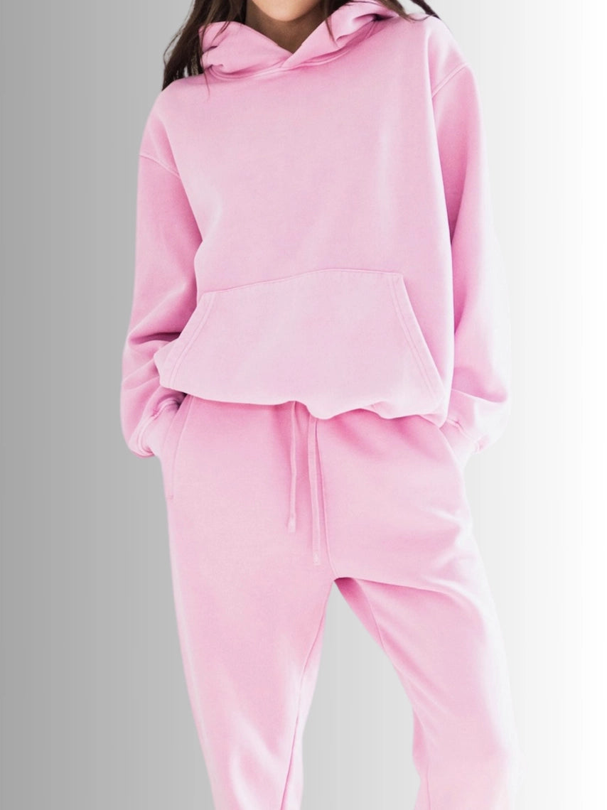 Pink tracksuit worn by a person on a gray background PRIV