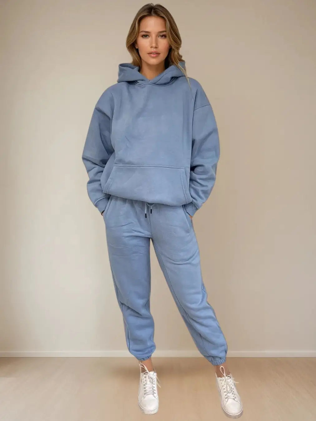 Women wearing a blue tracksuit with a plain background PRIV