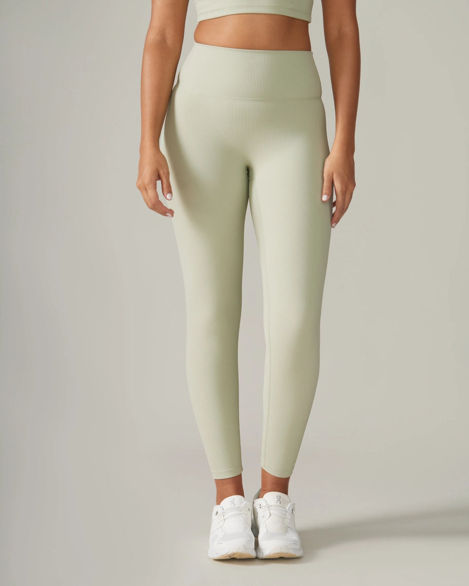 Women wearing light green leggings and white sneakers on a plain background Rose Boreal