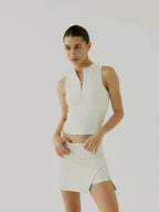 Woman wearing a cream BOV sleeveless top and skirt against a plain background