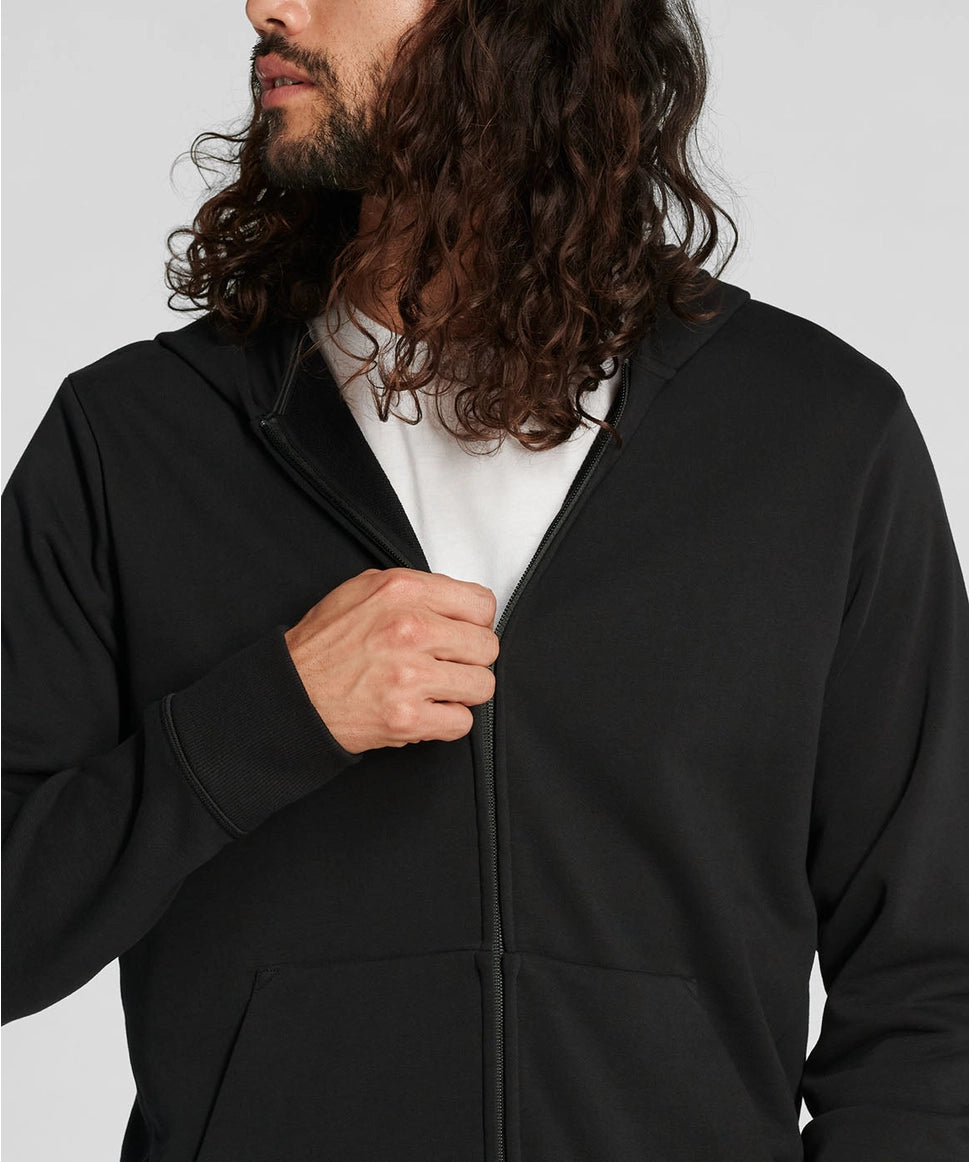 Person wearing a black hoodie with a plain background RYU