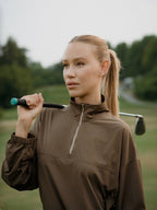 Woman holding a golf club on a golf course close up