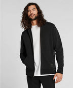 Man wearing a black jacket over a white shirt on a light gray background RYU