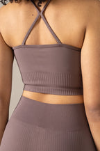 Brown ribbed crop top worn by a person against a neutral background