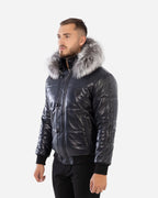 Man wearing a black leather jacket with fur hood on a white background 