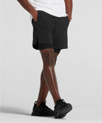 Man wearing black shorts and black sneakers on a light gray background RYU