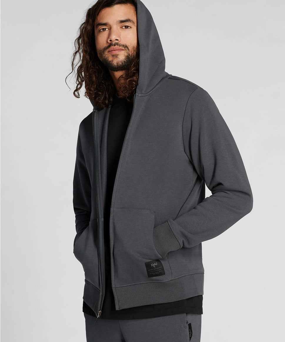 Man wearing a gray hoodie on a light gray background RYU