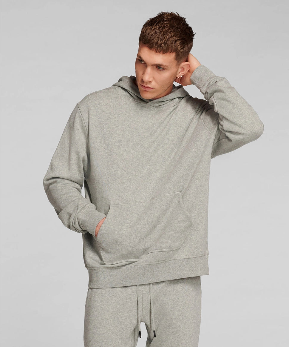 Man wearing a gray hoodie and pants on a light gray background RYU