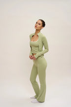 Woman wearing a green outfit on a plain background