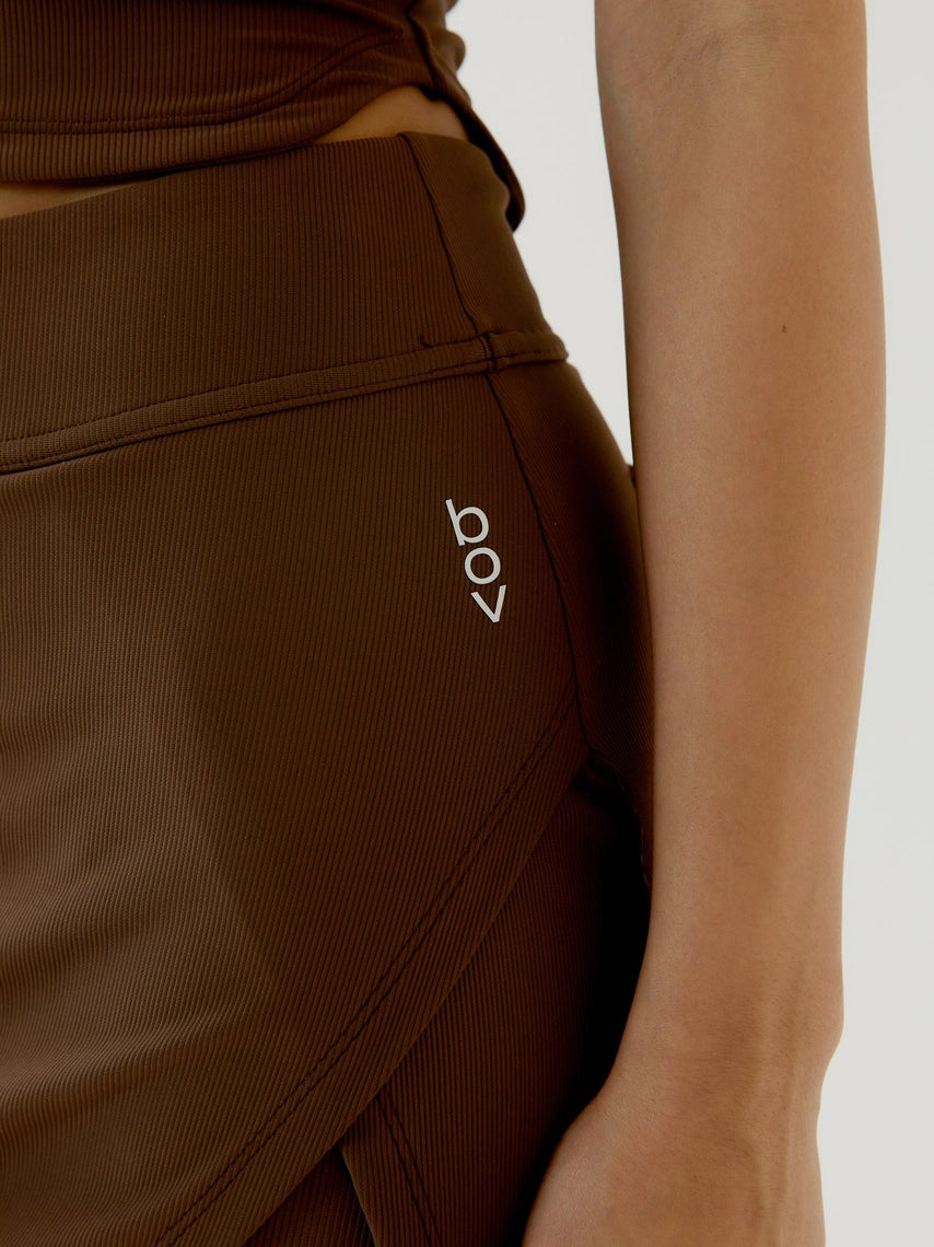 Brown skirt with a brand logo on a neutral background